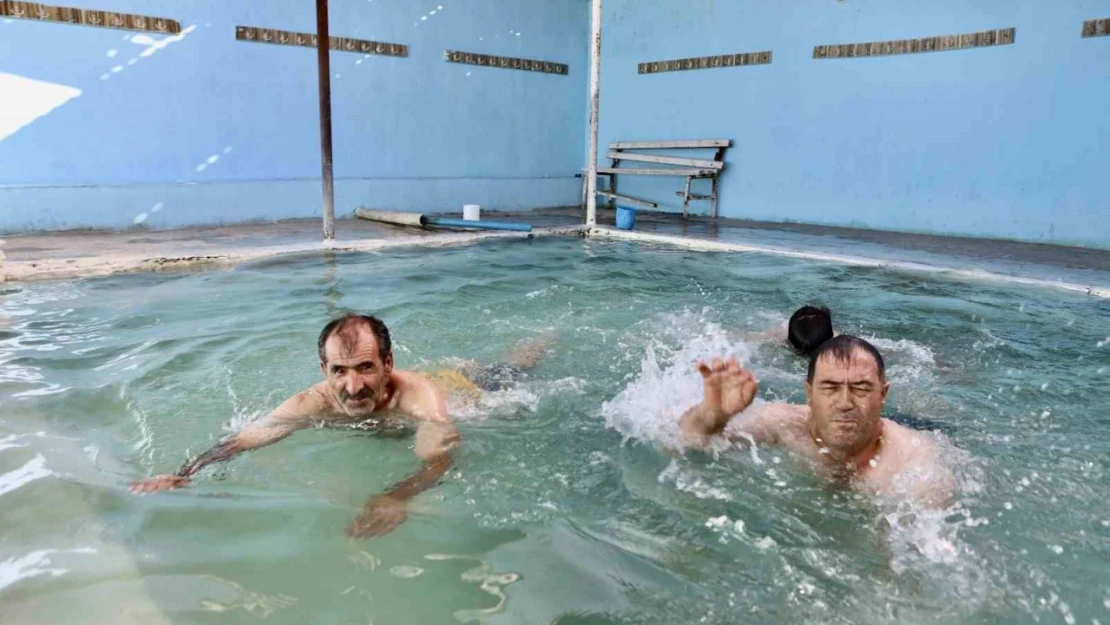Kavurucu sıcaklarda 50 dereceyi bulan suya girerek şifa arıyorlar